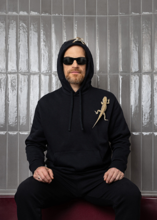 Portrait of Ulrich Troyer in 2024 with dwarf bearded dragons, photographed by Eva Kelety