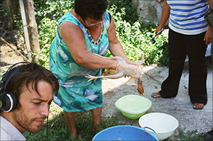 the farmerslady and her daughter are killing the chicken for the soup. kassian is recording the sounds.
