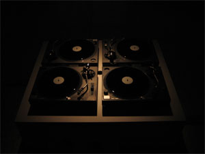 4 turntables on a platform and 4 dubplates with locked grooves